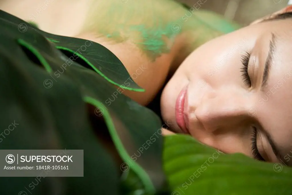 Young woman among leaves