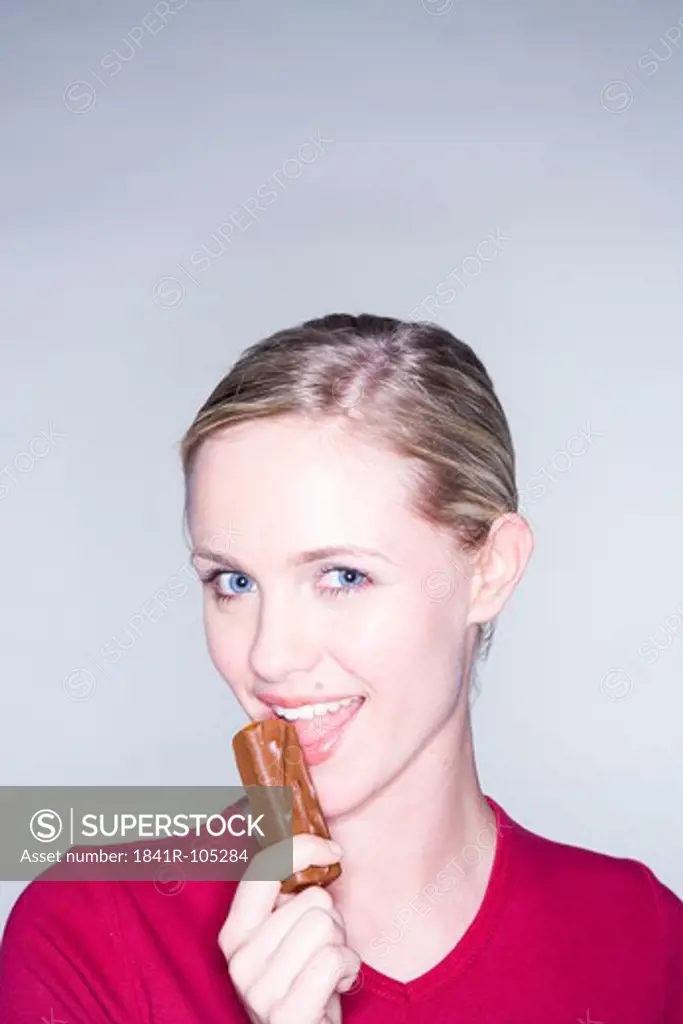 young woman eating chocolate bar