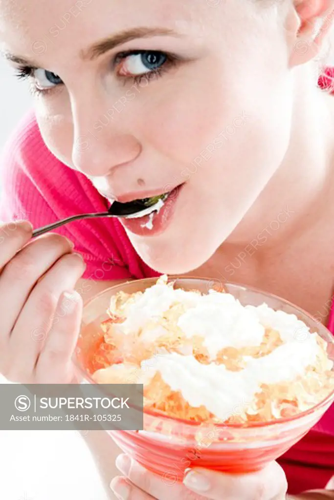 young woman eating jelly with cream