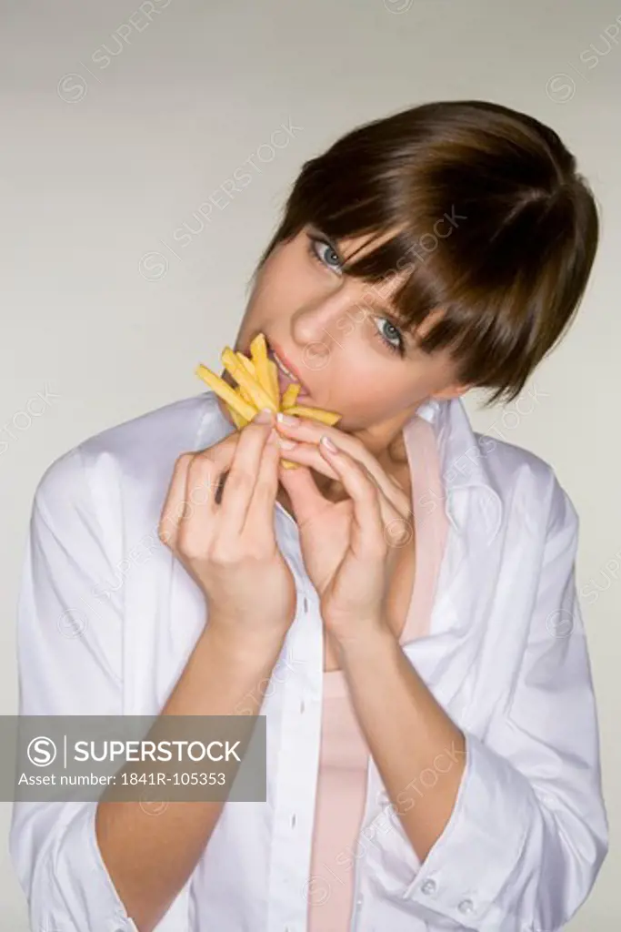 young woman with fries in mouth