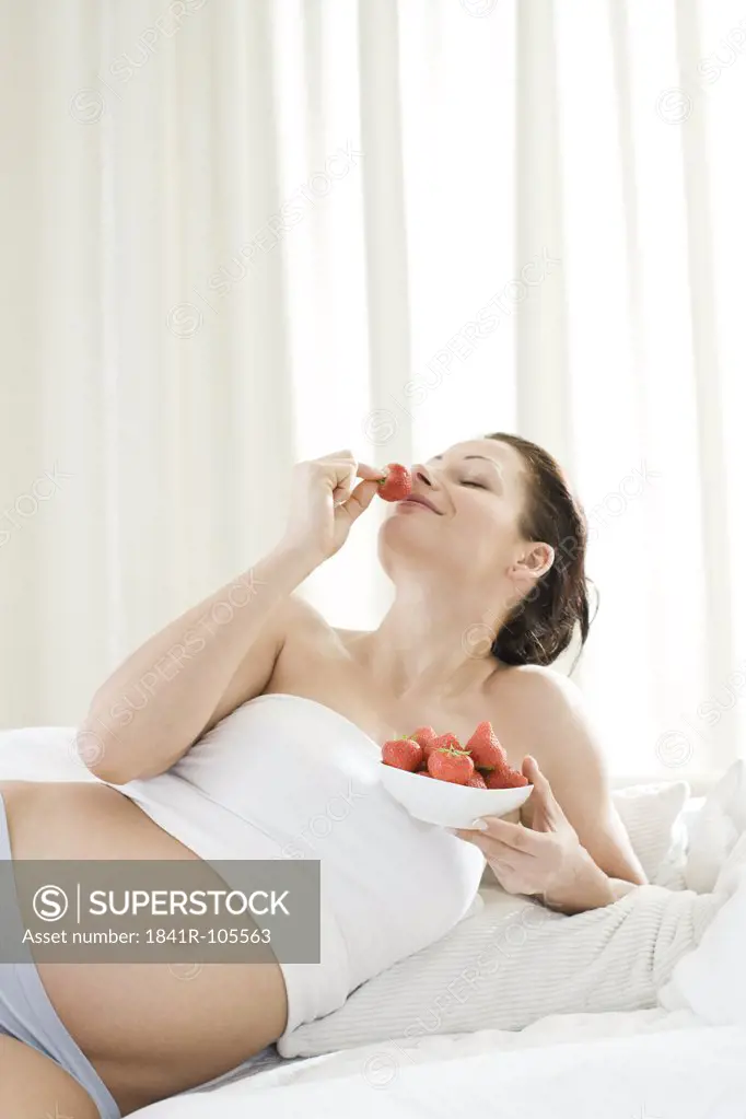pregnant woman eating strawberries