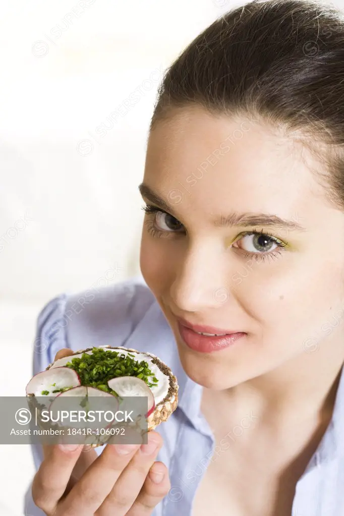 Young woman eating sandwich
