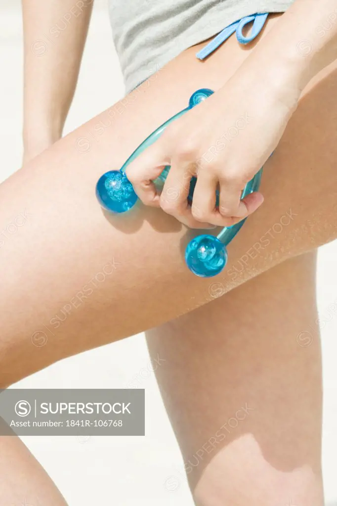 woman massaging thigh on beach