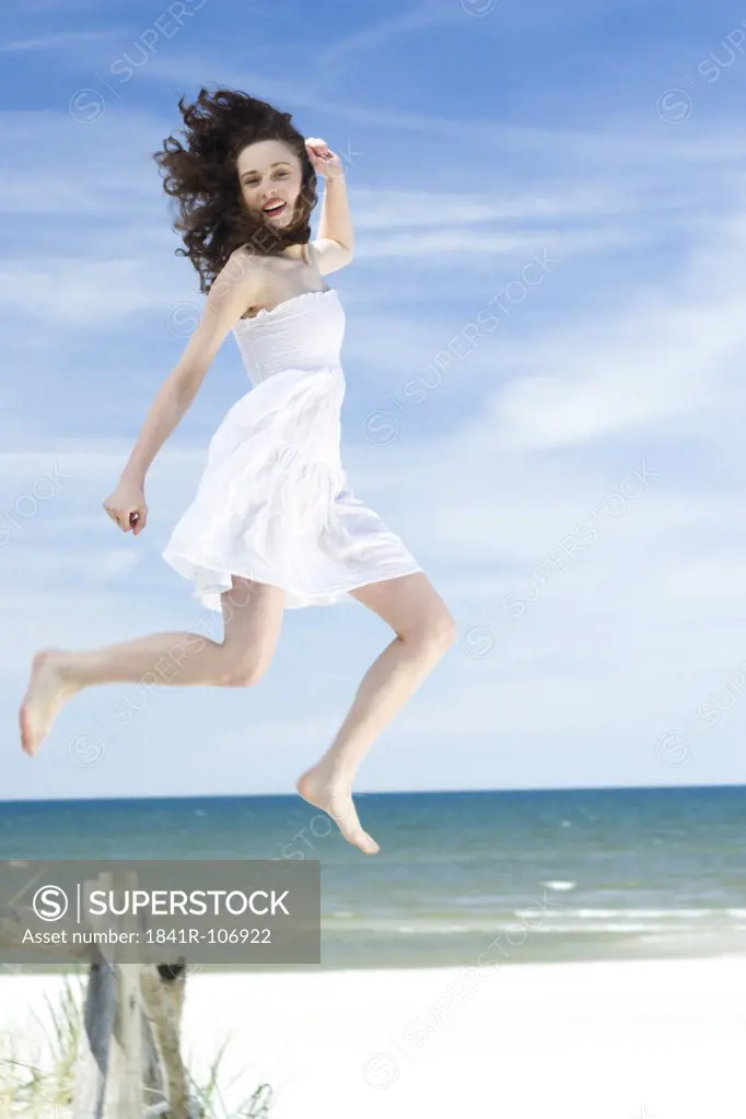 young woman jumping on beach