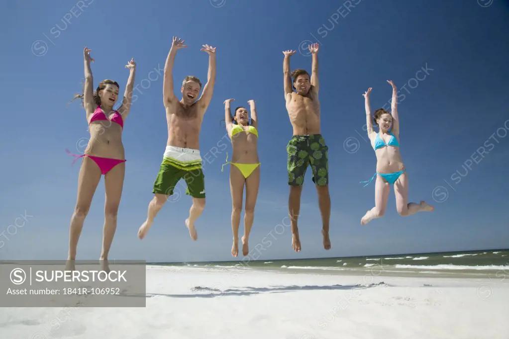 freinds jumping on beach