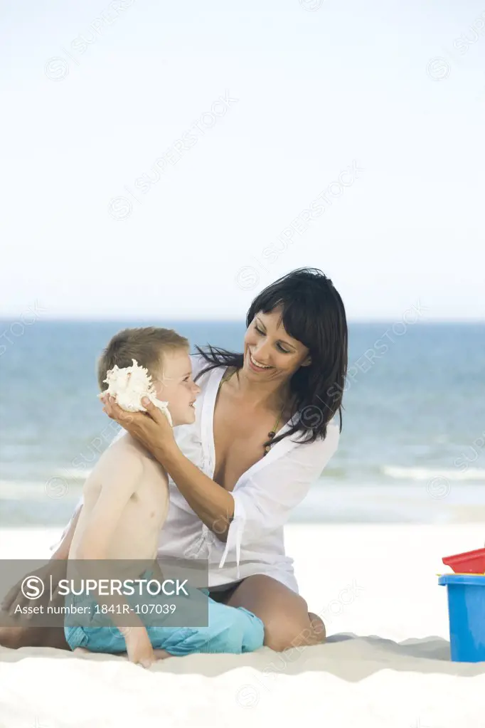 mother with son playing on beach