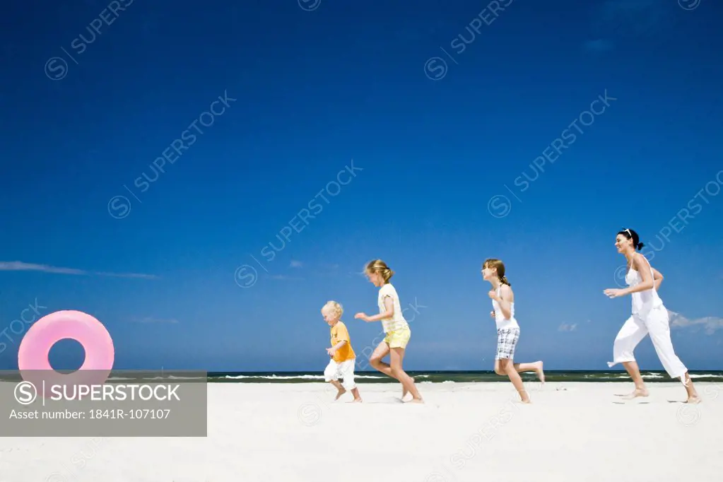 kids running after ball on beach