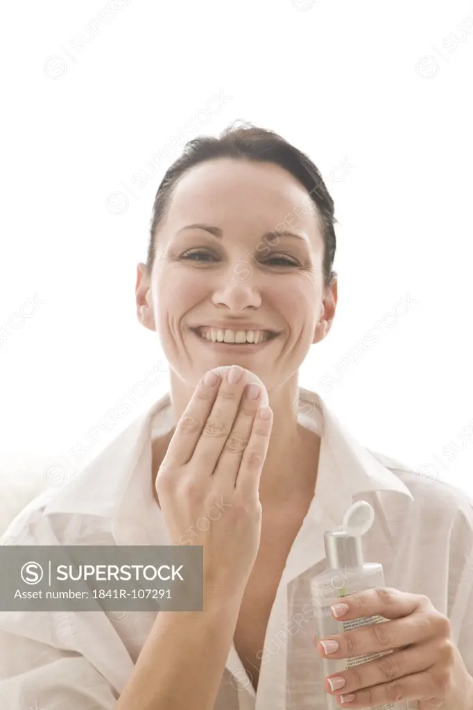 woman cleaning face with tonic