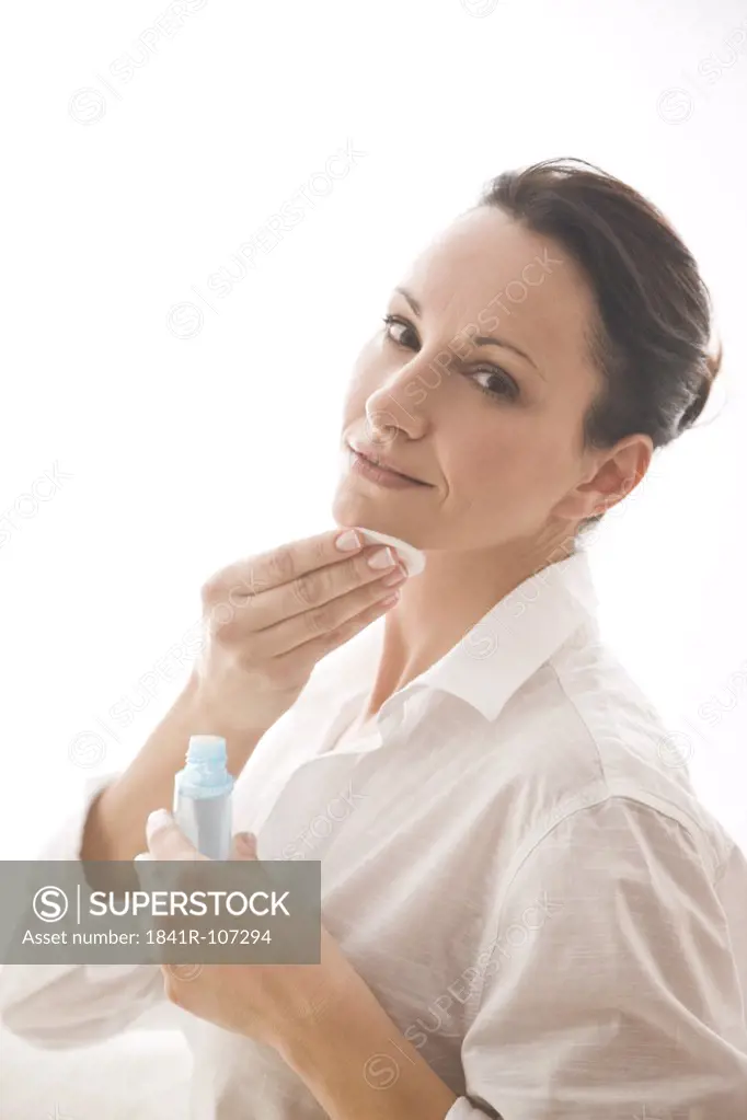 woman cleaning face with tonic