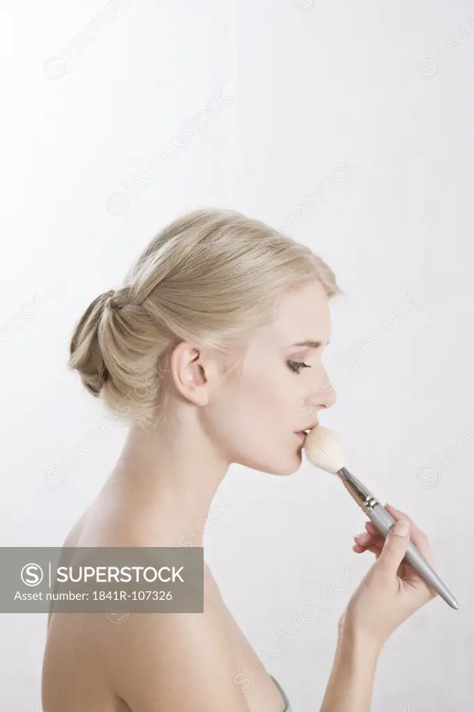 woman applying powder on her lips