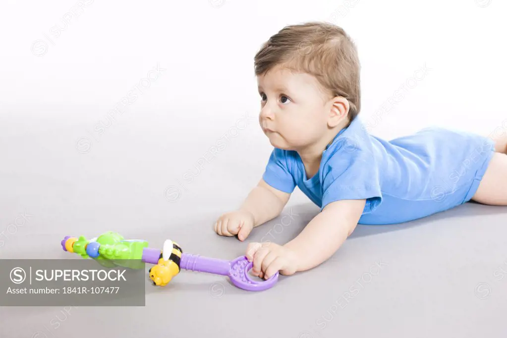 Baby on floor with toy