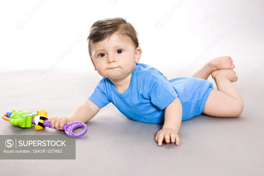 Baby on floor with toy
