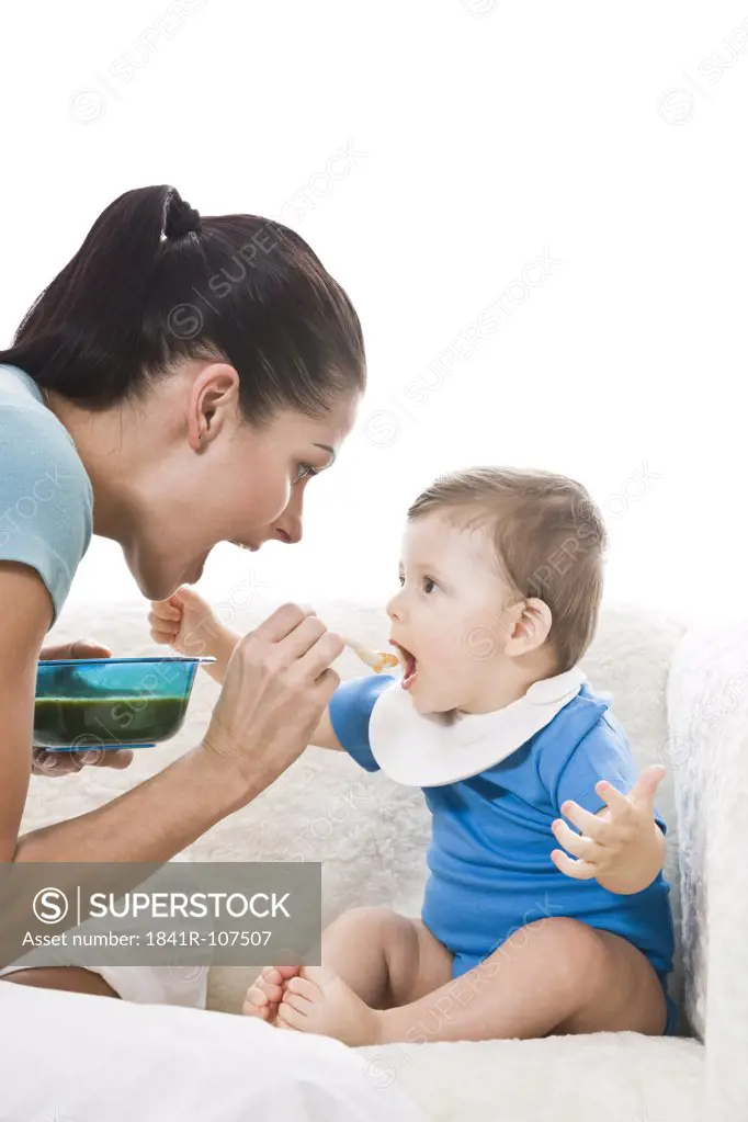 Mother feeding baby in bib