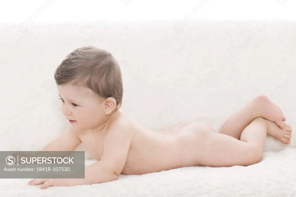 Nude baby lying on sofa