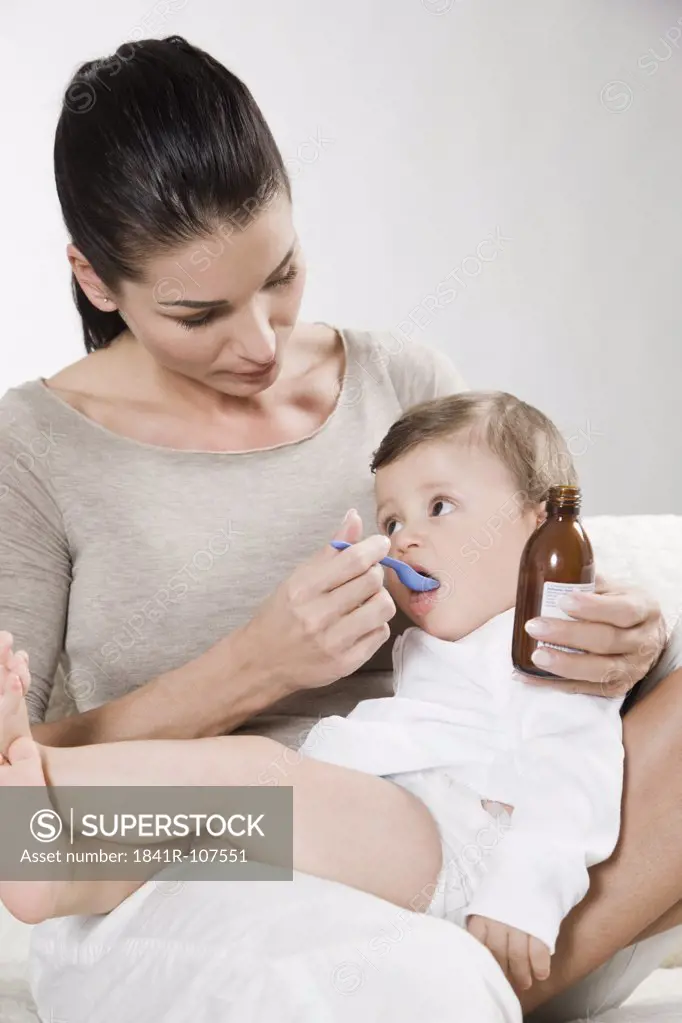 Mother gives syrup to sick baby