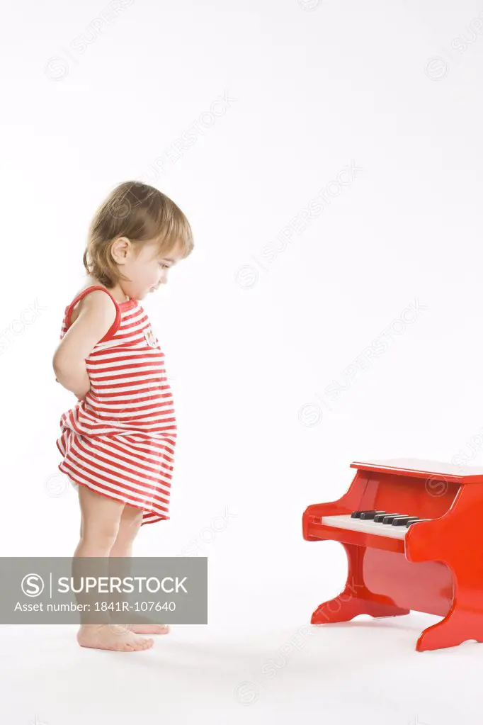 toddler girl playing on piano