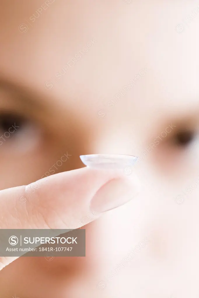 woman putting on eye lenses