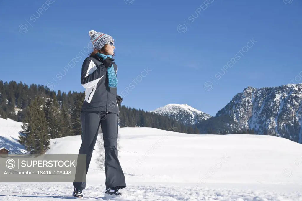 Woman jogging in winter landscape, Tannheimer Tal, Tyrol, Austria