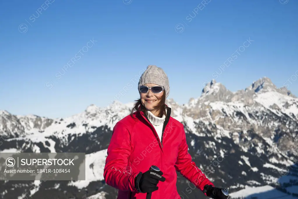 Smiling woman with ski poles in winter landscape, Tannheimer Tal, Tyrol, Austria