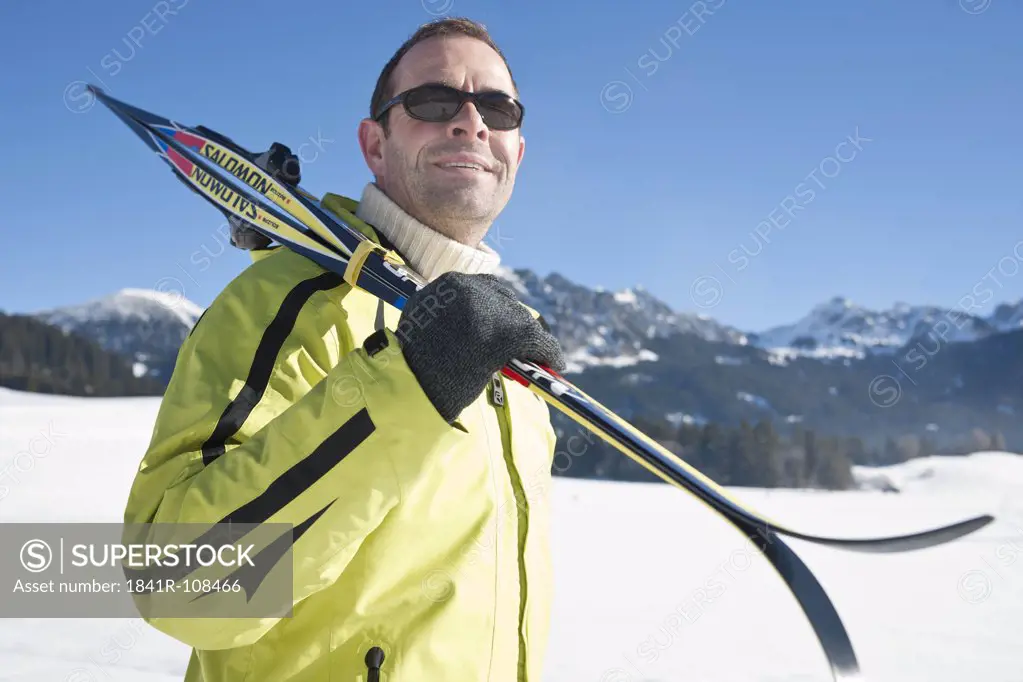 Man with skis in winter landscape, Tannheimer Tal, Tyrol, Austria