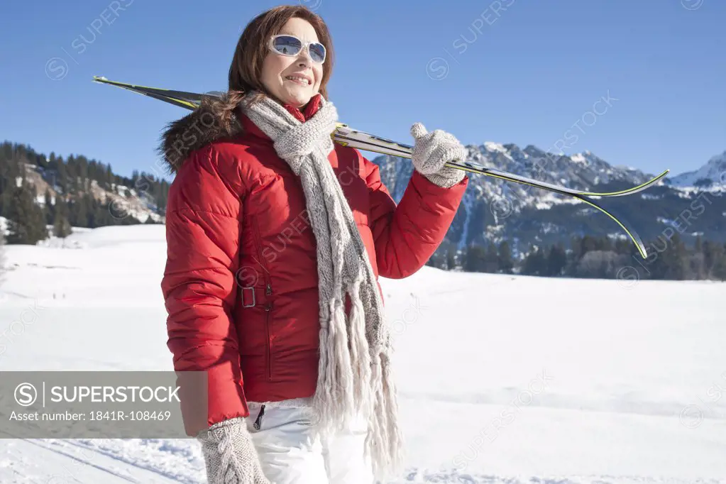 Woman with skis in winter landscape, Tannheimer Tal, Tyrol, Austria