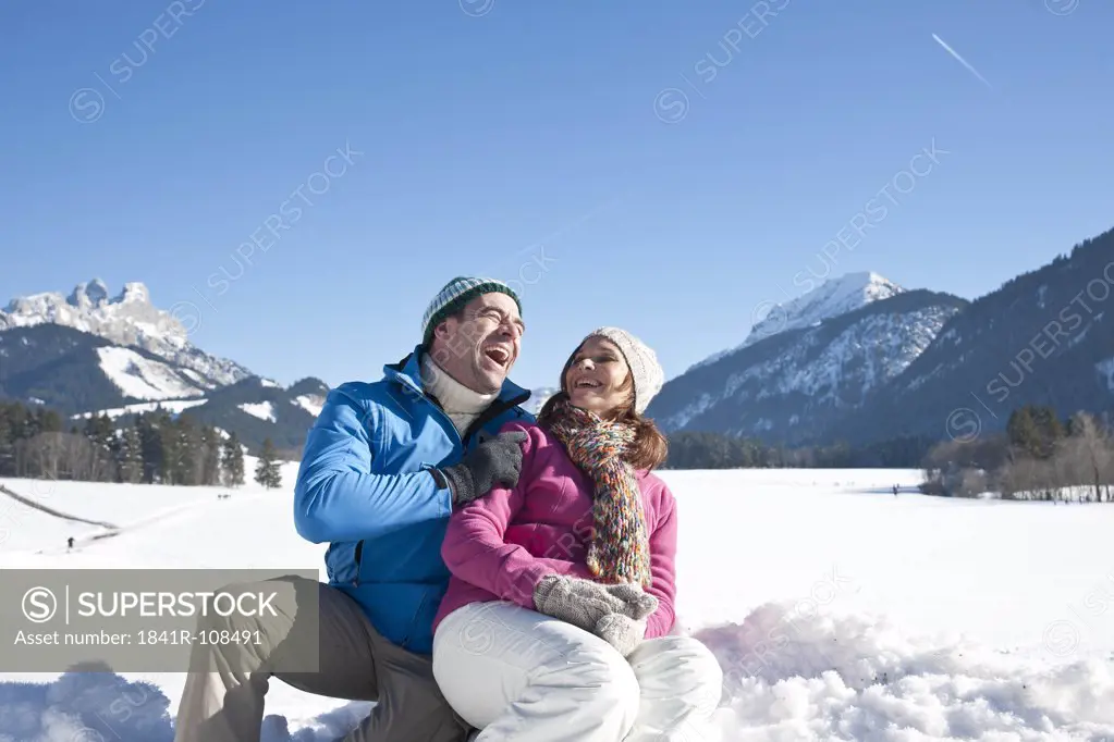 Happy couple in winter landscape, Tannheimer Tal, Tyrol, Austria