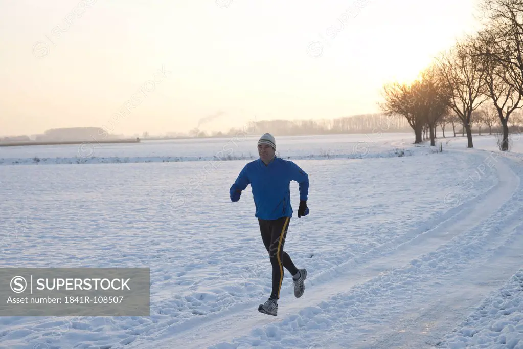 Man jogging in snow, Tannheimer Tal, Tyrol, Austria