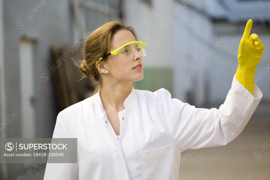 Young woman with lab coat and protective glasses