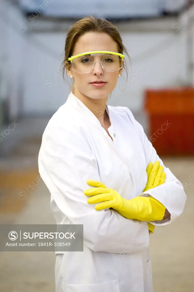 Young woman with lab coat and protective glasses
