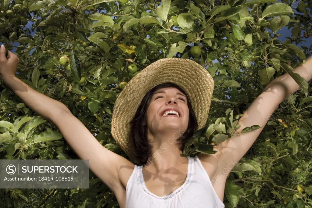 Happy young woman at apple tree