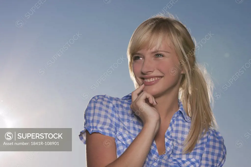 Young blond woman wearing checkered blouse outdoors