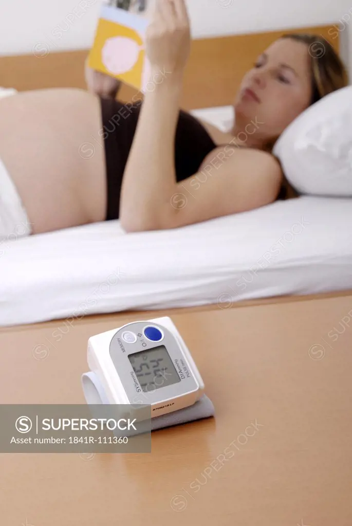 Pregnant woman reading with sphygmometer