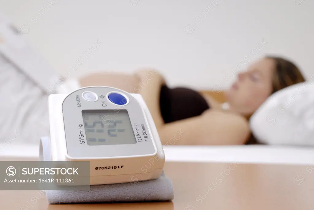 Pregnant woman sleeping with sphygmometer