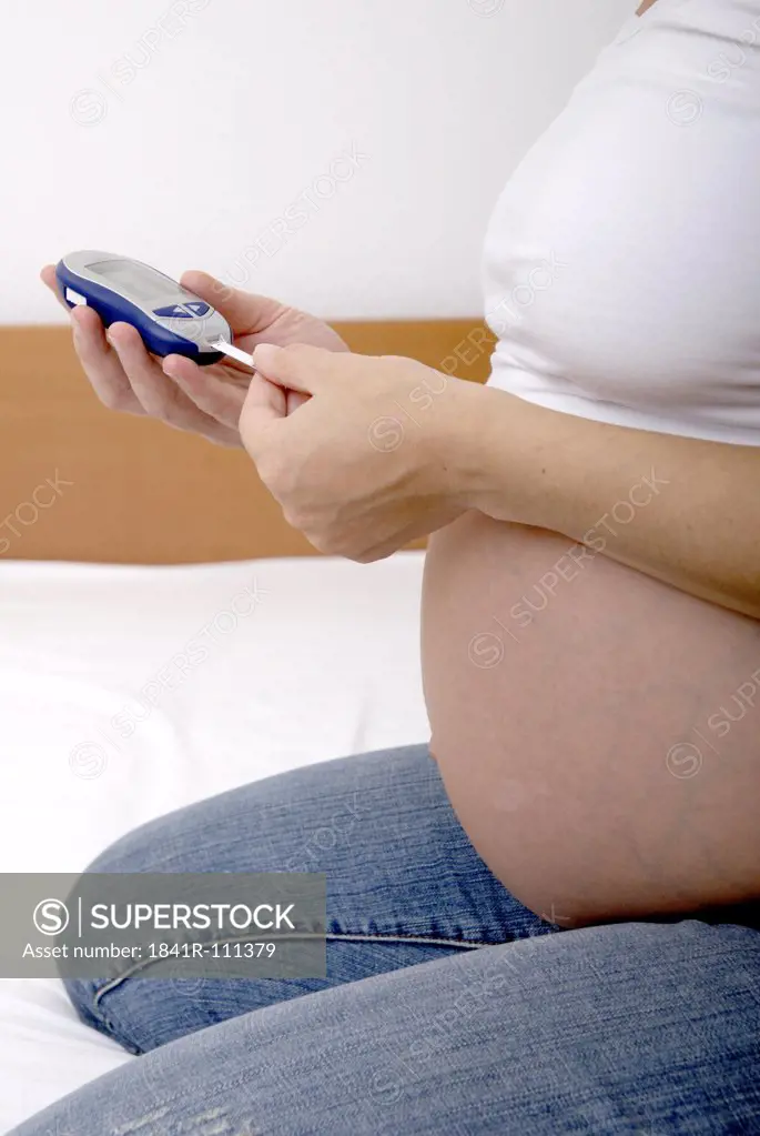 Pregnant woman with equipment für insulin therapy