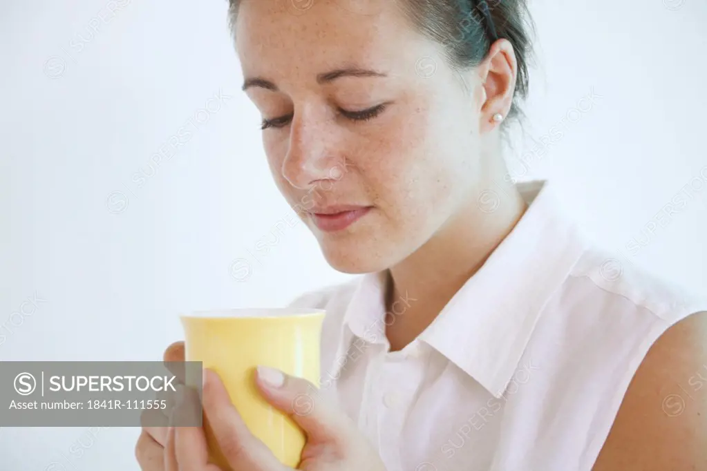 Young woman holds a cup.