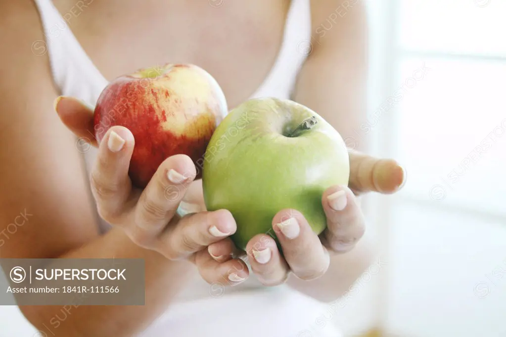Female hands holding apples.