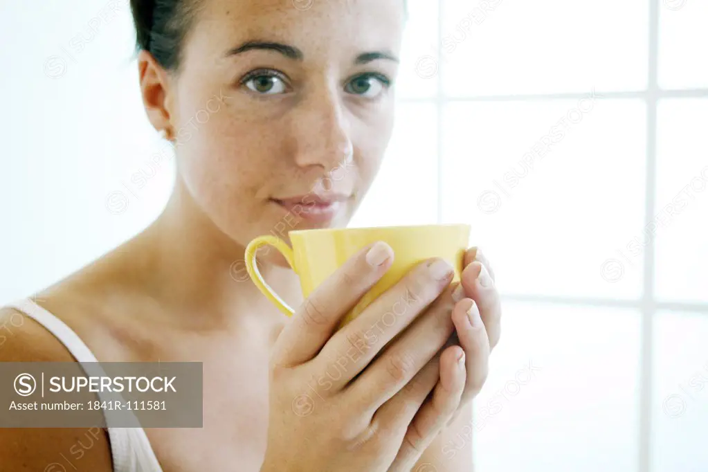 Young woman holds a cup.
