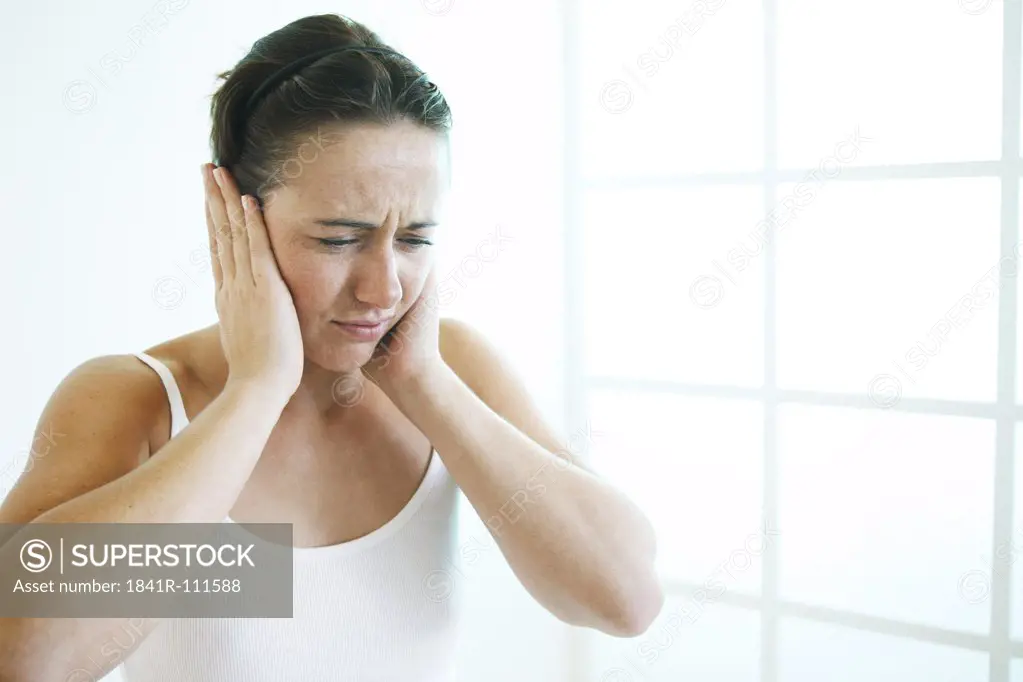 Young woman keeps her ears closed