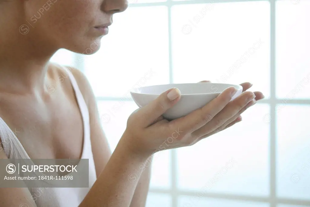 Female hands holding a bowl.
