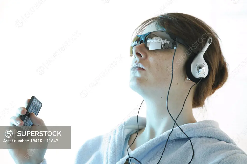 portrait of a young woman wearing glasses and headset and holding the remote control in her hand -Brainlight - brainlight - brain light