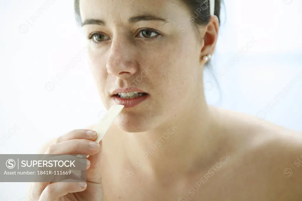 portrait of a young woman holding a chewing gum für dental care in her hand