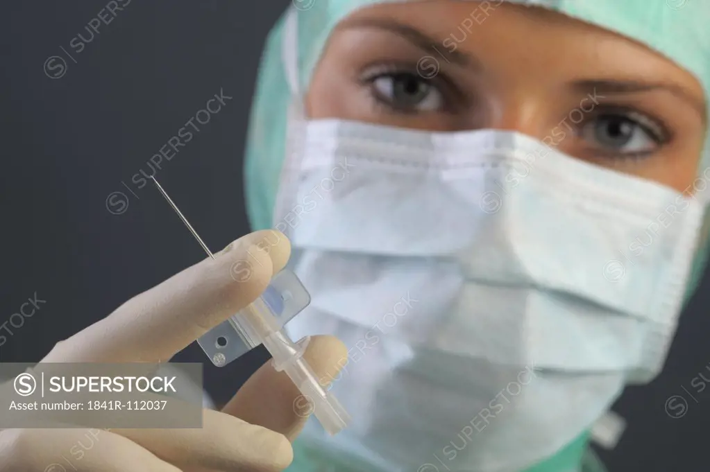young woman is holding an injection in her hand. She is ready für an operation