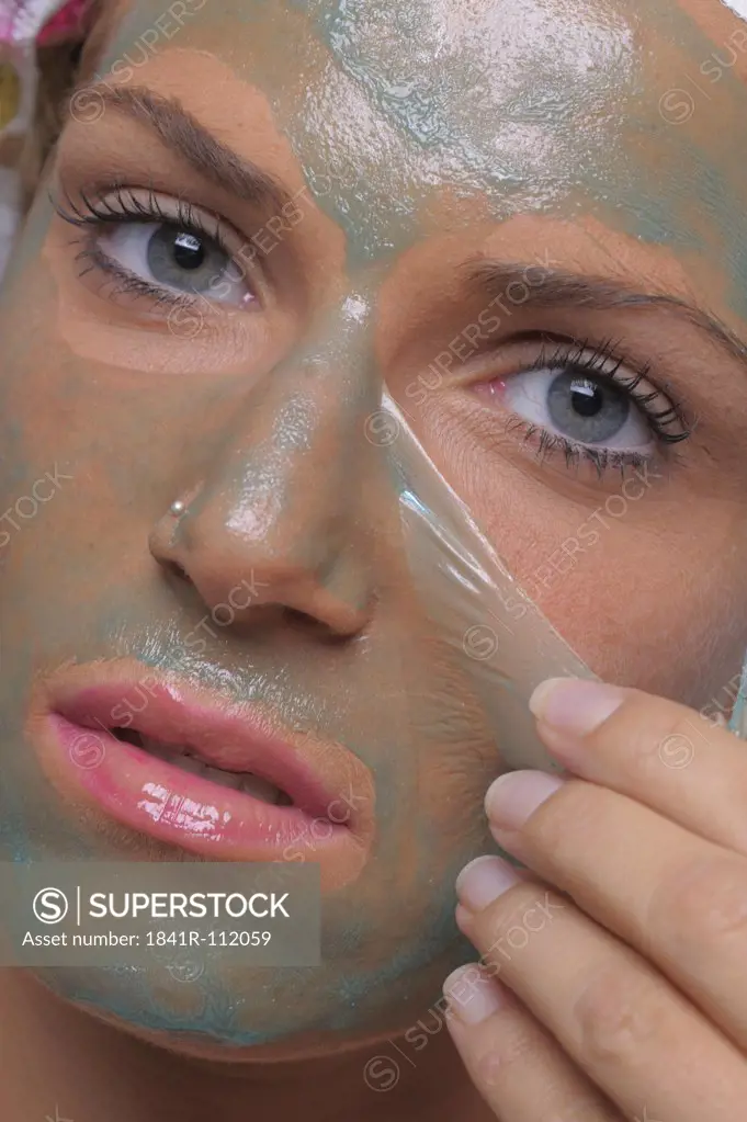 Young woman removes the face mask