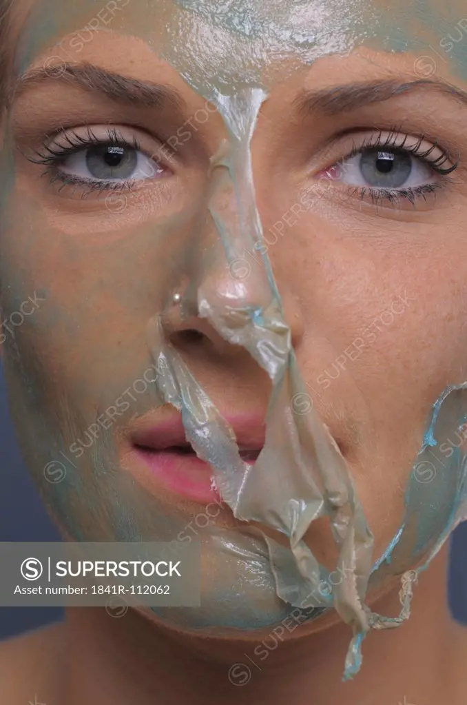 Young woman with halfway through removed face mask