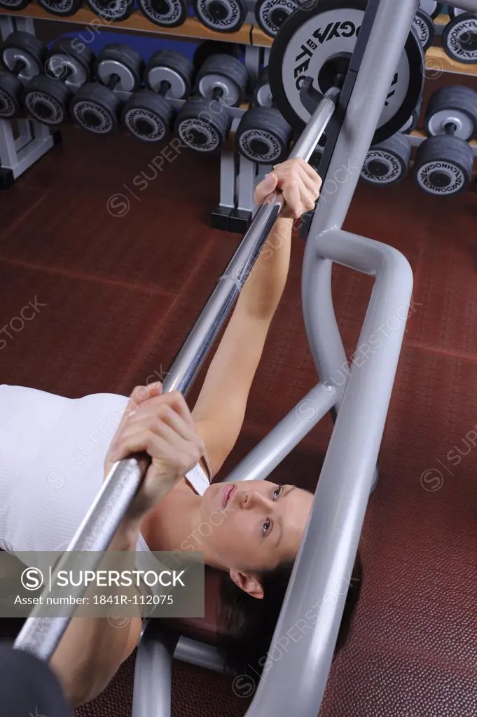 young woman in a fitness center weight lifting