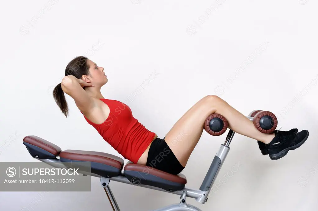 Young woman training her abdominal muscles , abs