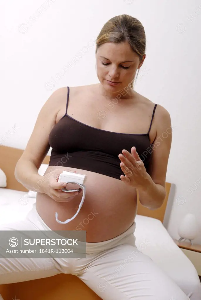 pregnant woman meassuring her arterial blood pressure