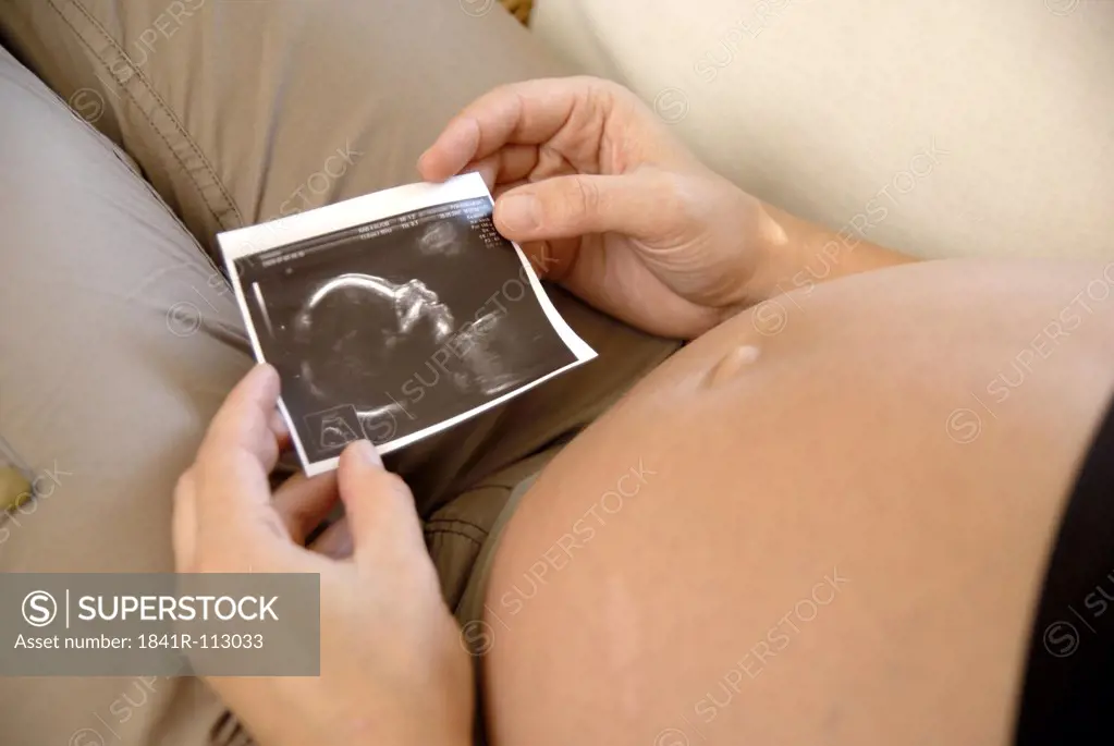 Pregnant woman looking at ultrasound pictures