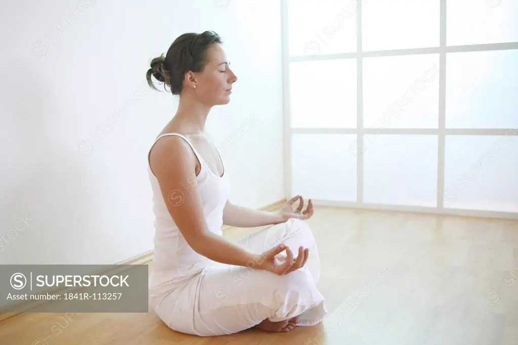 Side view of a meditating young woman.