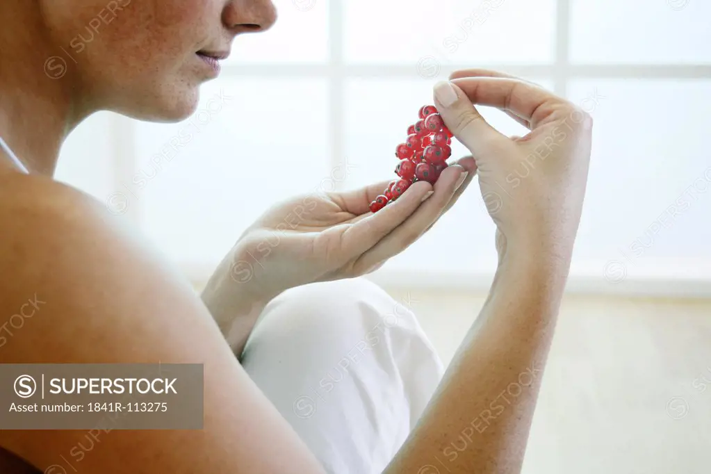 Young woman holding berries in her hand.